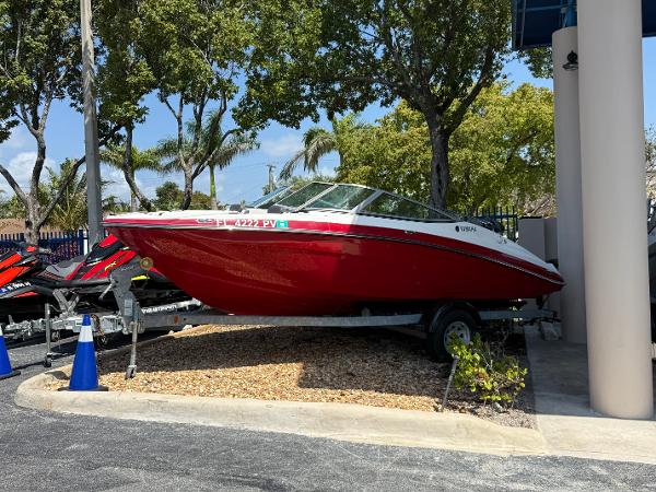 Yamaha Boats SX192 2015 Yamaha Boats SX192 in vibrant red, parked on a trailer under sunny skies.