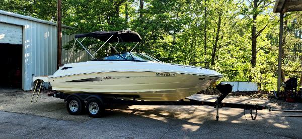 Sea Ray SDX 220 2017 Sea Ray SDX 220 boat on trailer, parked outdoors near trees and a building.