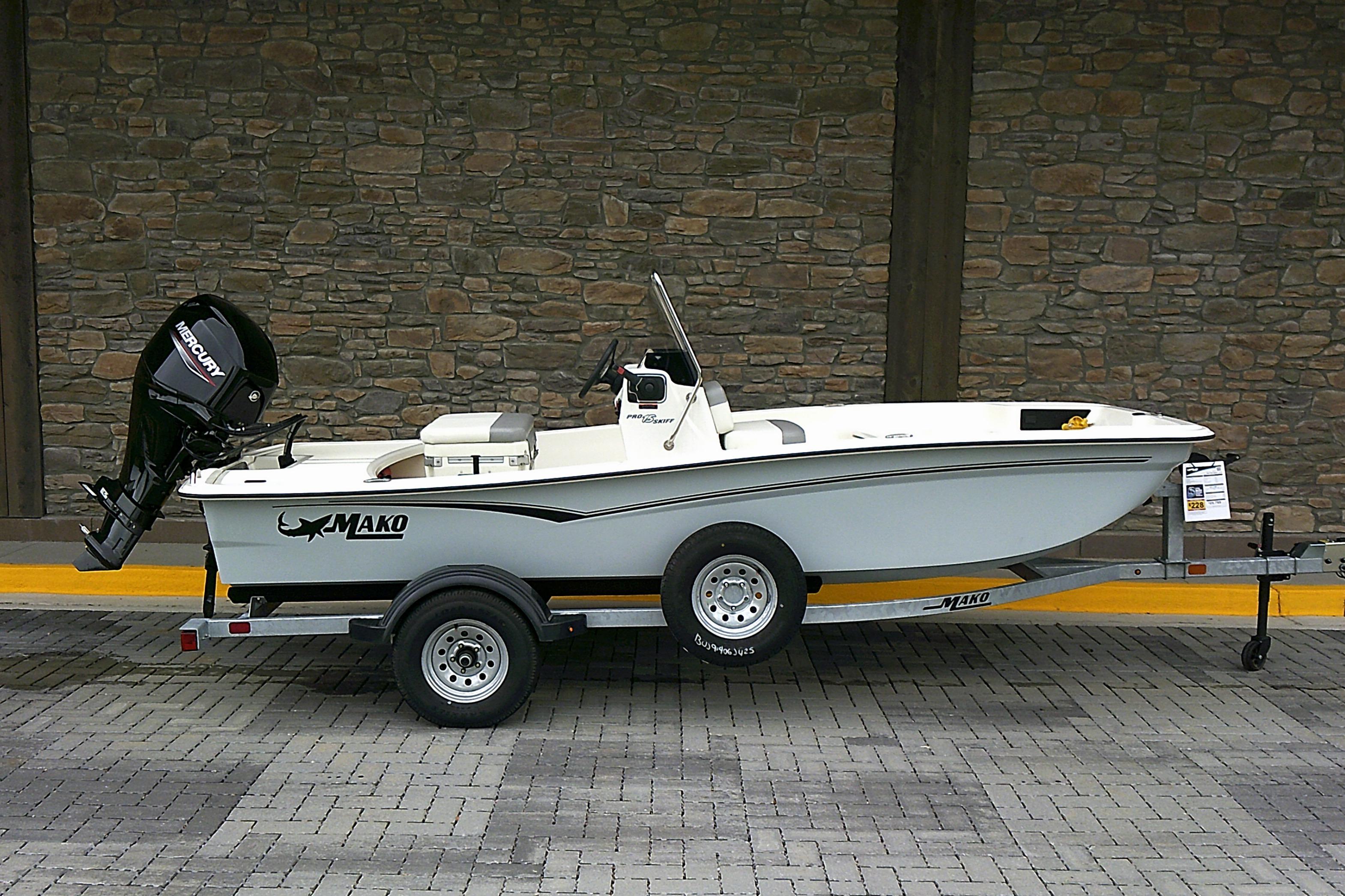 Mako Pro Skiff 15 CC 2025 Mako Pro Skiff 15 CC boat on trailer, parked against stone wall.
