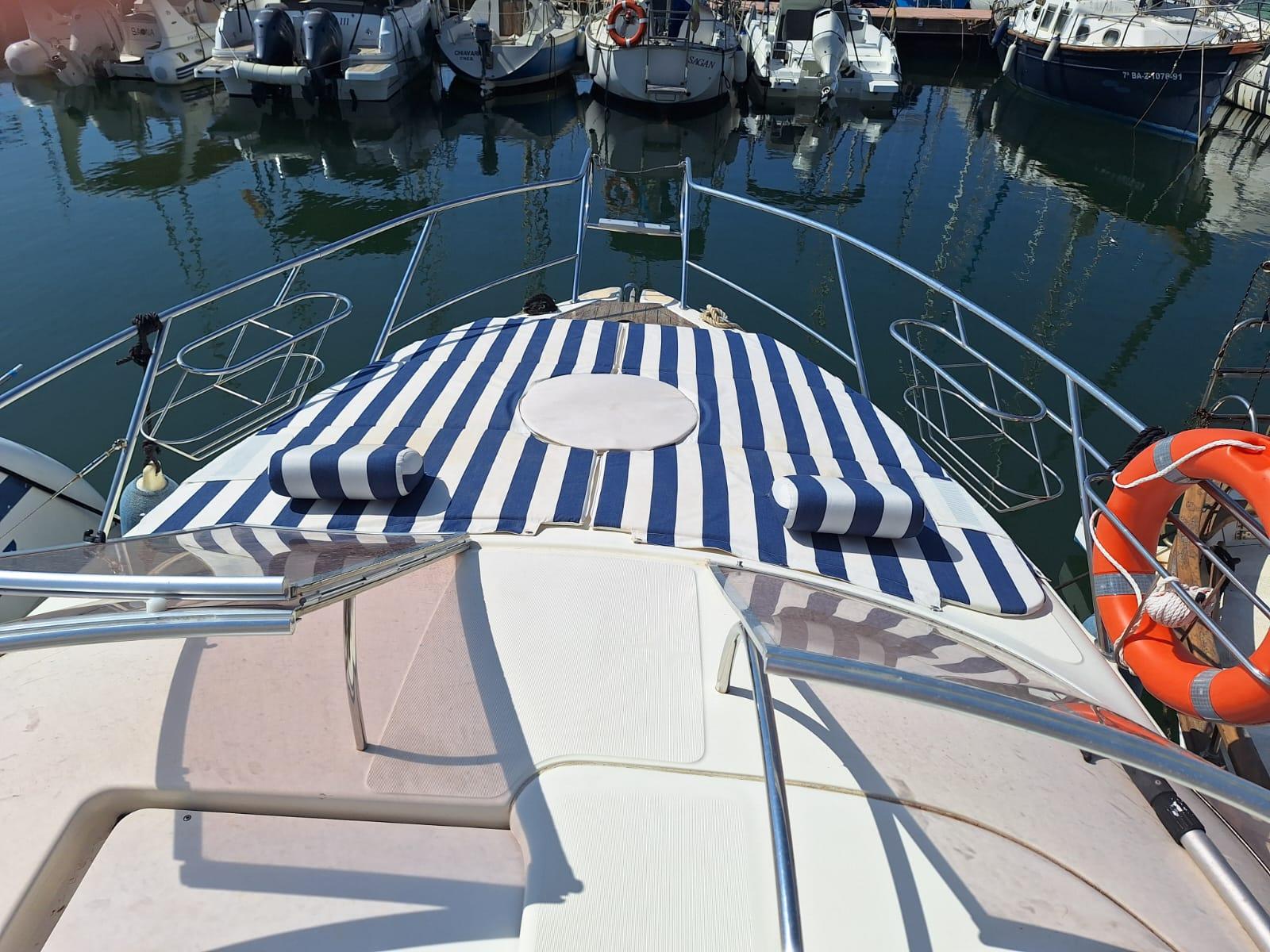 Cranchi Zaffiro 28 2004 Cranchi Zaffiro 28 yacht with striped sunbed, docked in marina.