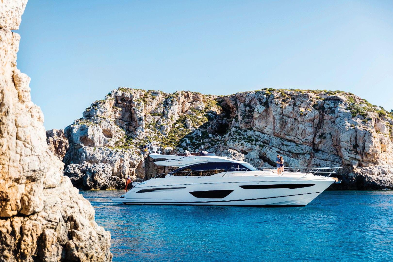 Princess S65 2018 Princess S65 yacht cruising near rocky cliffs in clear blue waters.