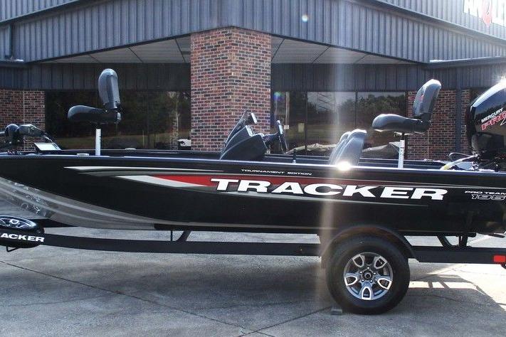Tracker Pro Team 195 Tournament Edition 2026 Tracker Pro Team 195 Tournament Edition boat, black with red accents, parked outside a building.