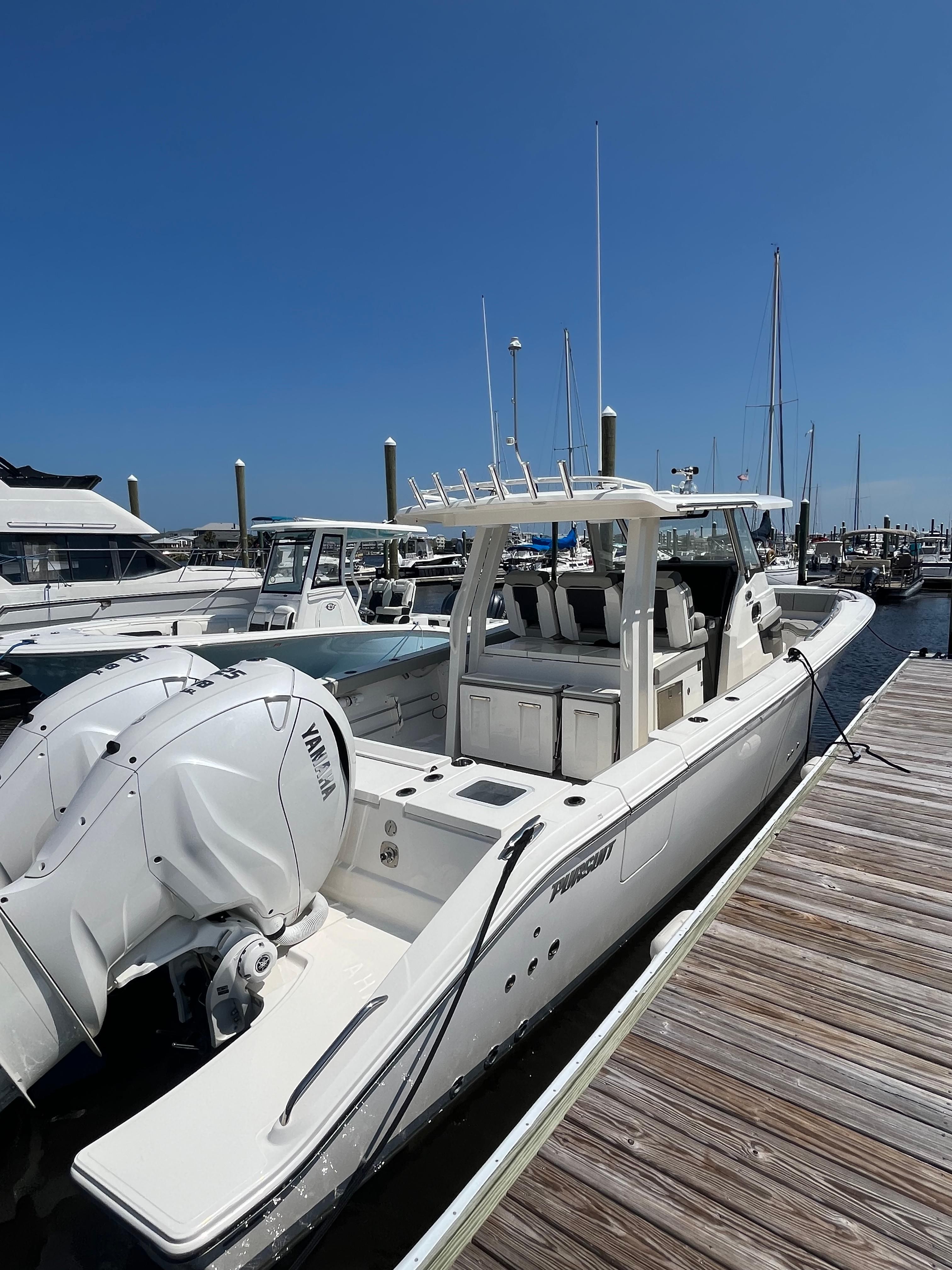 Pursuit S358 2022 Pursuit S358 boat docked at marina with Yamaha engines.