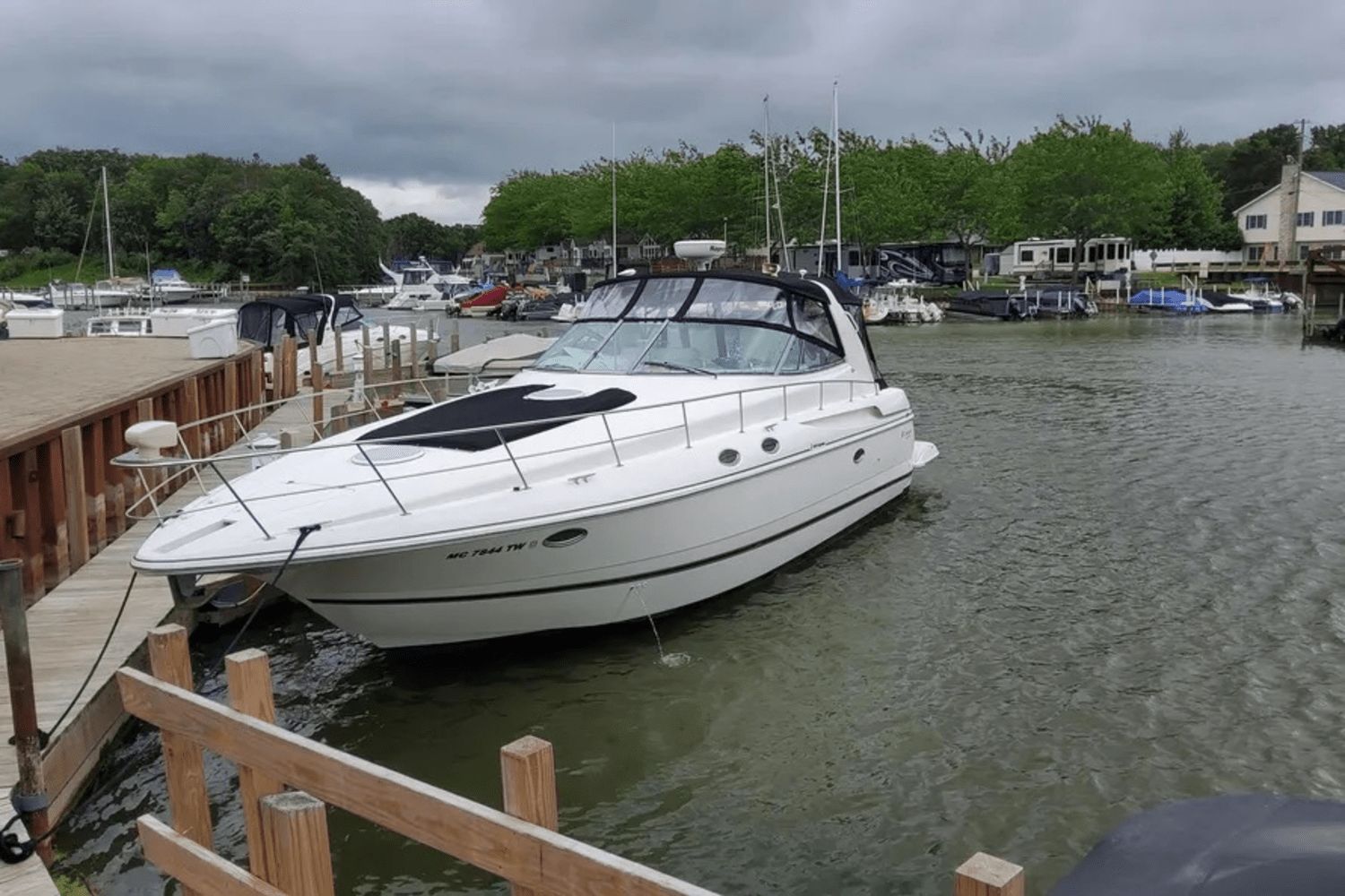 Cruisers Yachts 3870 2000 Cruisers Yachts 3870 docked in a marina with overcast skies.
