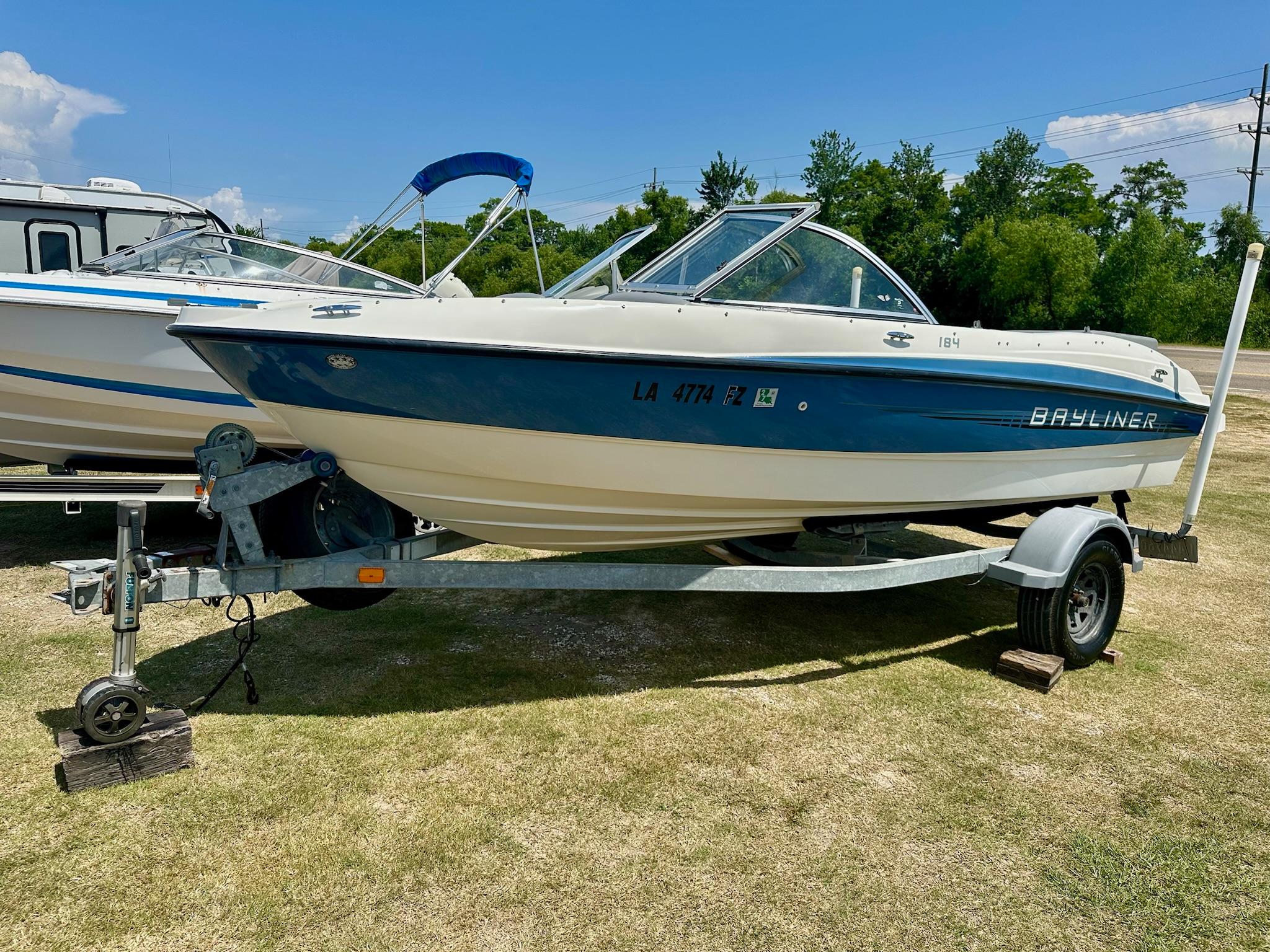 Bayliner 184 SF 2011 Bayliner 184 SF boat on trailer, parked on grass under clear blue sky.