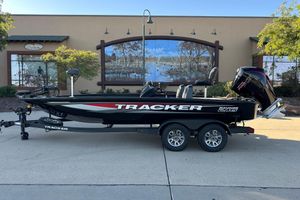 Tracker Savage 215 2025 Tracker Savage 215 boat on trailer, parked outdoors with scenic mural background.
