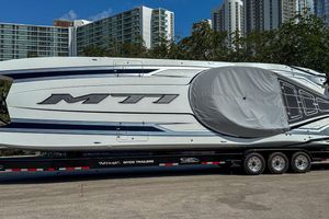 MTI 440X 2024 MTI 440X boat on trailer, urban backdrop, clear sky.