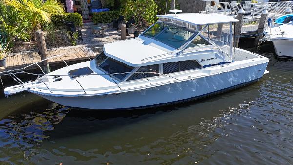 Bertram 30 Express 1984 Bertram 30 Express boat docked on a sunny day, surrounded by greenery.