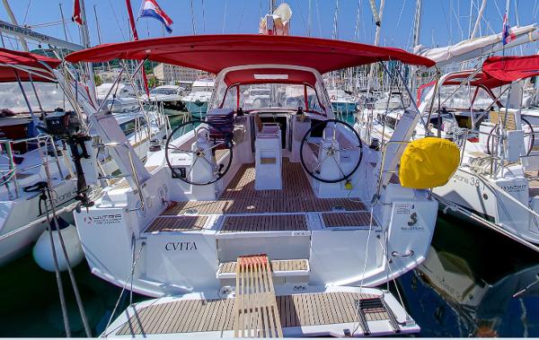 Beneteau Oceanis 38.1 2019 Beneteau Oceanis 38.1 yacht docked in marina, featuring dual steering wheels and red canopy.