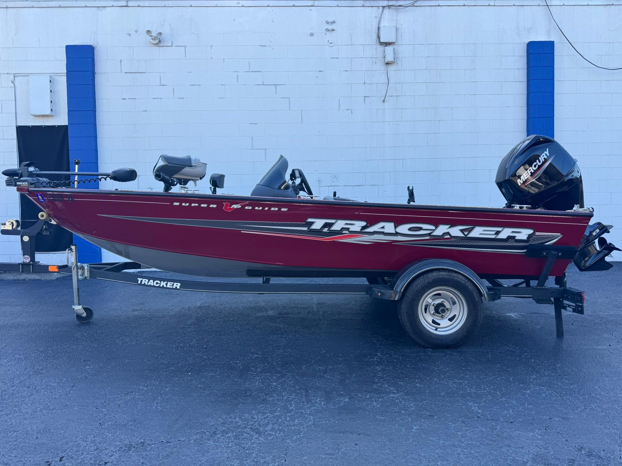Tracker Super Guide V-16 SC 2019 Tracker Super Guide V-16 SC boat on trailer, red exterior, parked outdoors.