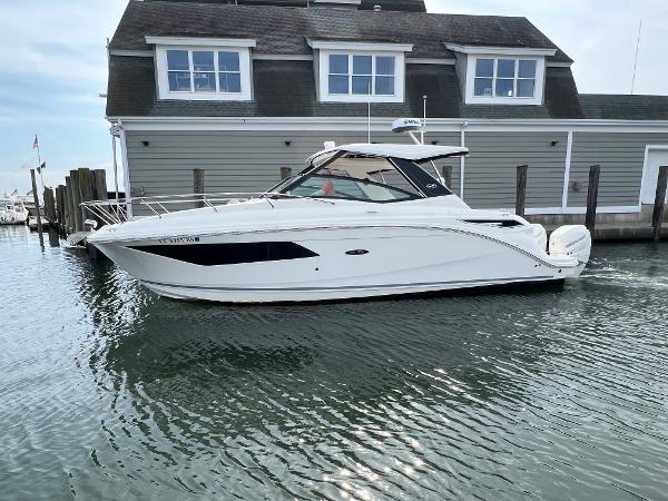 Sea Ray Sundancer 320 Outboard 2022 Sea Ray Sundancer 320 OB boat docked by a waterfront building.