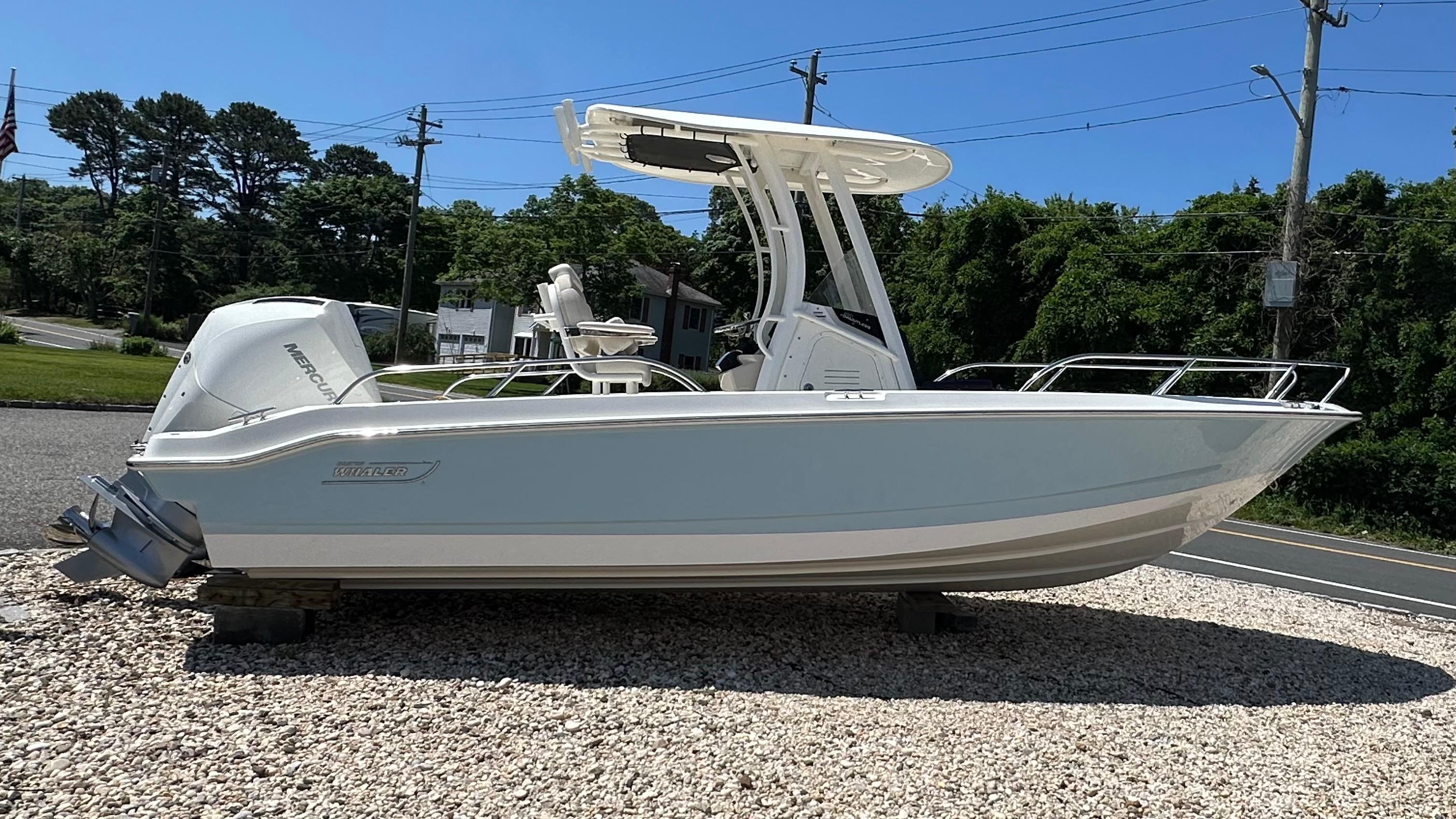 Boston Whaler 220 Dauntless 2025 Boston Whaler 220 Dauntless boat displayed outdoors on gravel.