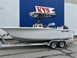 Sea Pro 225FLX Sandbar 2025 Sea Pro 225 Sandbar boat on trailer, parked outside a blue and white building.