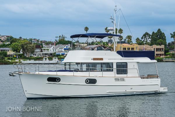 Beneteau Swift Trawler 44 Beneteau Swift Trawler 44, 2018 model, cruising on a calm waterway with scenic background.