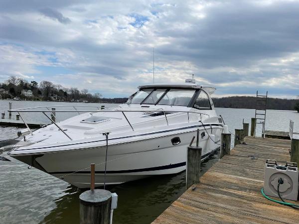 Regal 35 Sport Coupe 2018 Regal 35 Sport Coupe docked by a scenic lake under a cloudy sky.