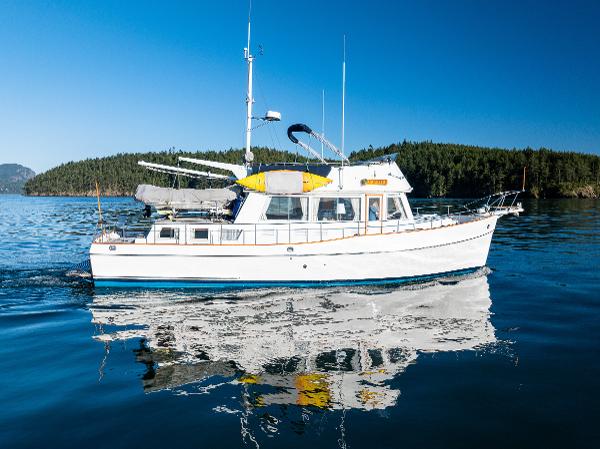Grand Banks Aft Cabin 42 Classic 1995 Grand Banks Aft Cabin 42 Classic yacht cruising on a serene lake.