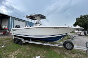 Triton 2486cc 2007 Triton 2486cc boat on trailer, parked outdoors near a blue building.