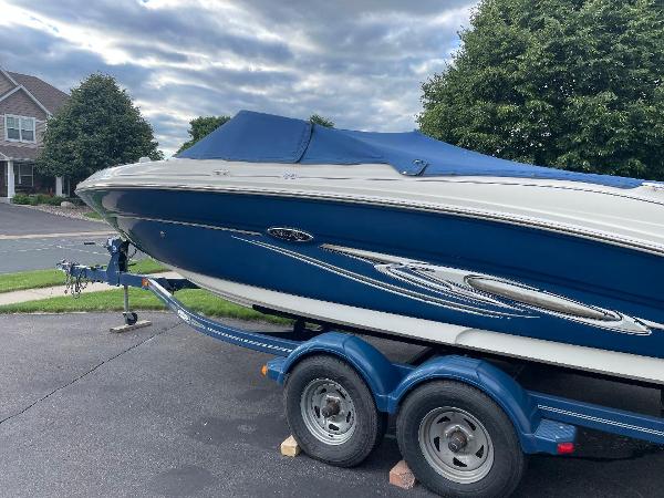 Sea Ray 210 Select 2007 Sea Ray 210 Select boat on trailer, blue cover, parked in residential driveway.