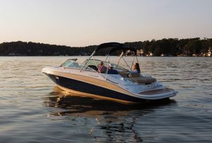 Four Winns H260 2012 Four Winns H260 boat cruising on a serene lake at sunset.