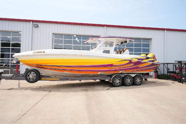 Sunsation 34 CCX 2014 Sunsation 34 CCX boat with vibrant yellow and purple design on a trailer.
