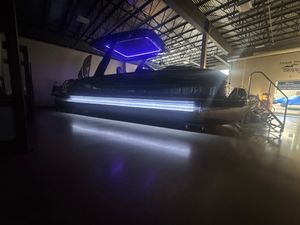 Barletta RESERVE V26 MTT 2023 Barletta RESERVE V26 MTT pontoon boat with blue LED lights in a showroom.