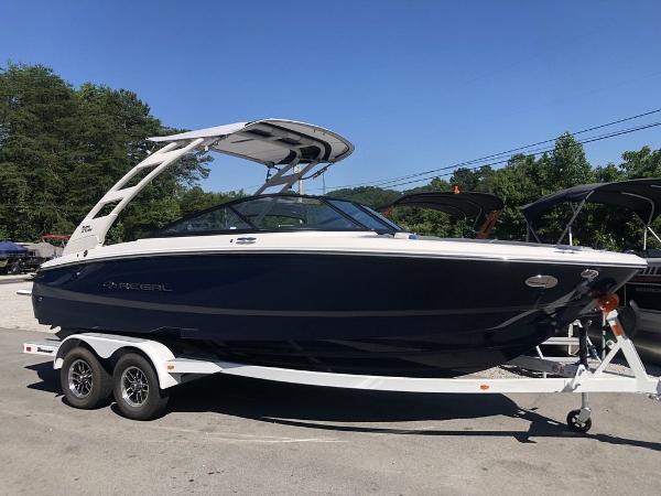 Regal LS2 Ultimate 2025 Regal LS2 Ultimate boat on trailer, parked outdoors under clear blue sky.