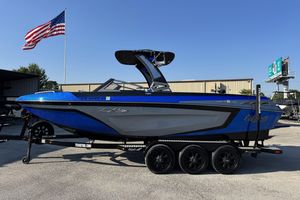 Tigé ZX5 2019 Tigé ZX5 boat on trailer, blue and gray, with American flag in background.