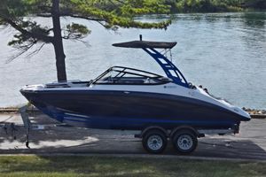 Yamaha Boats AR210 2020 Yamaha AR210 boat on trailer by a lake, under tree shade.