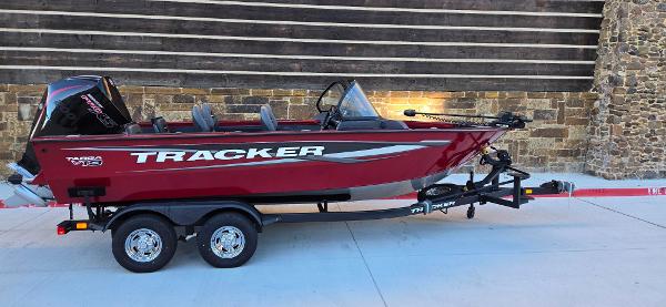 Tracker Targa V-19 Combo 2025 Tracker Targa V-19 Combo boat on trailer, red exterior, parked outdoors.