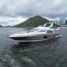 Azimut 66 2017 Azimut 66 yacht cruising near scenic coastline with hills and modern buildings.
