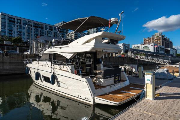 Bavaria Virtess 420 Fly 2019 Bavaria Virtess 420 Fly yacht docked in urban marina under clear blue sky.