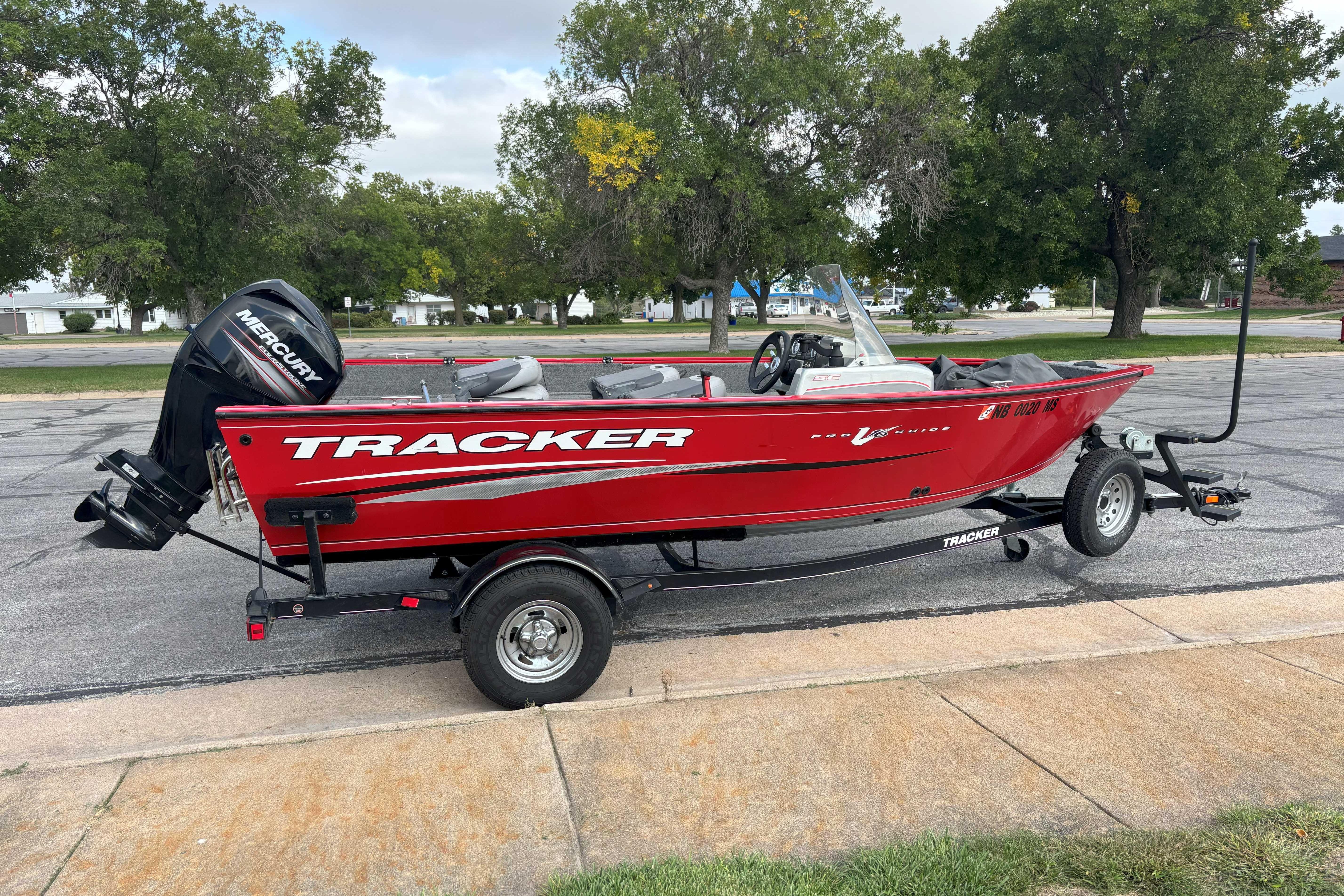 Tracker Pro Guide V-16 SC 2016 Tracker Super Guide V-16 SC boat on trailer, red exterior, parked outdoors.