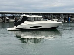Regal 36 Grande Coupe 2023 Regal 360 Grande Coupe yacht on calm water near a marina.
