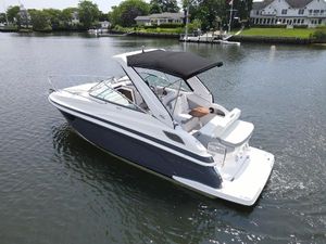 Regal 28 Express 2024 Regal 28 Express boat on calm water with black canopy.