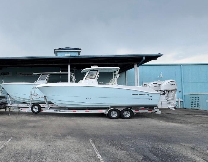 Twin Vee 280 GFX2 CC 2025 Twin Vee 280 GFX2 CC boat on trailer, parked near blue building.