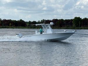 SeaHunter 28 Floridian 2023 SeaHunter 28 Floridian boat cruising on a calm lake under a cloudy sky.