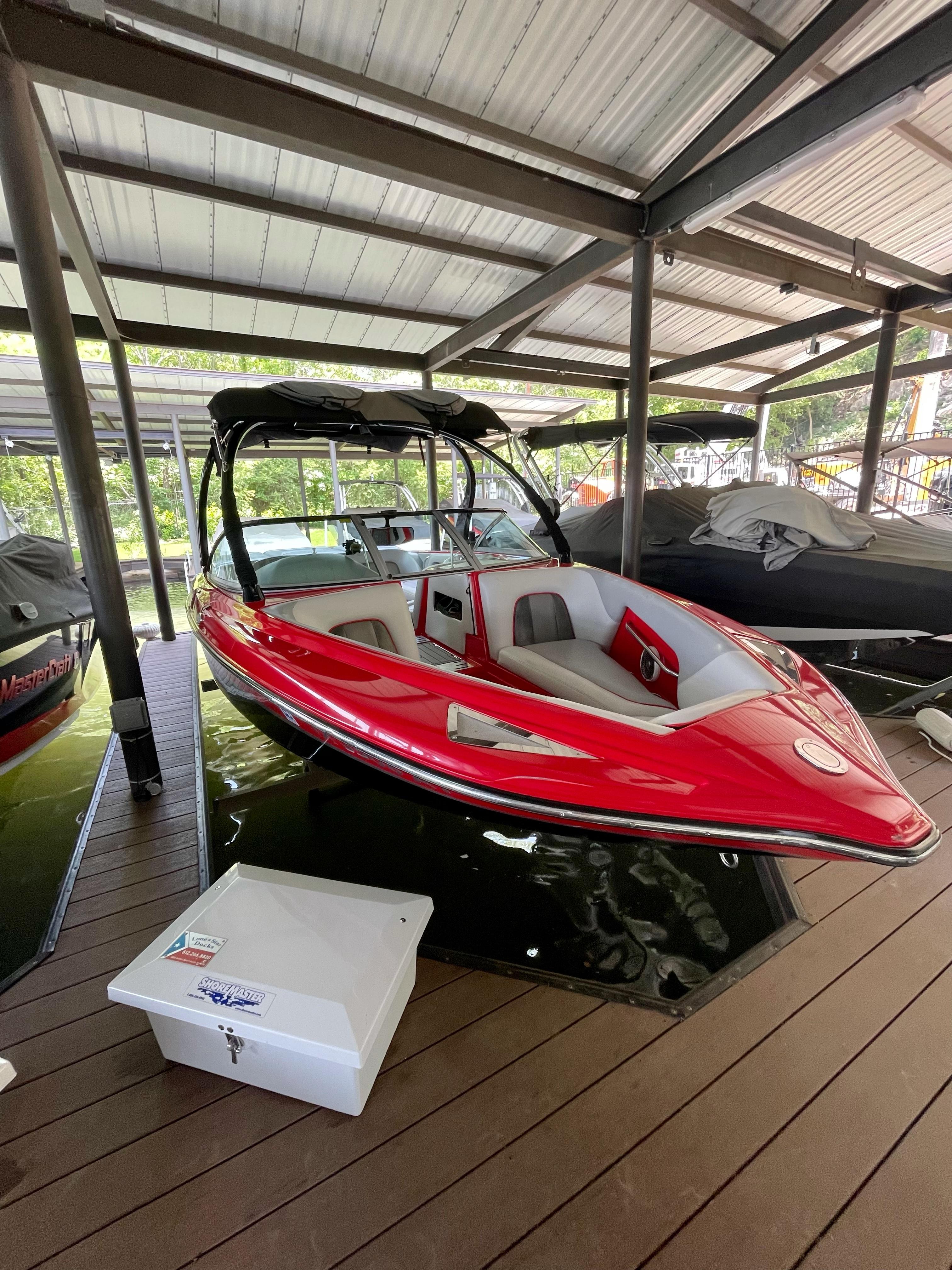 Centurion Enzo SV230 Red 2009 Centurion Enzo SV230 boat docked under a covered marina.