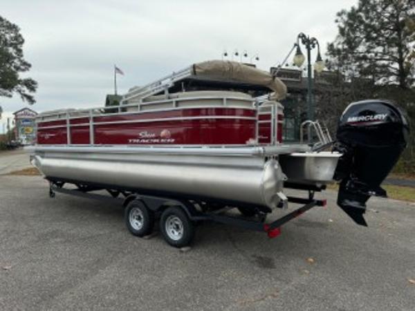 Sun Tracker Party Barge 22 DLX 2025 Sun Tracker Party Barge 22 DLX pontoon boat on trailer, parked outdoors.