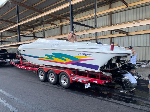 Baja 302 BOSS 1996 Baja 302 BOSS speedboat on red trailer in storage facility.