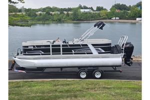 Starcraft EX 22 R 2023 Starcraft EX 22 R pontoon boat on trailer by a scenic lake.