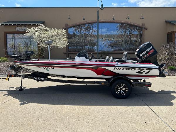 Nitro Nitro Z7 DC 2015 Nitro Z7 DC boat with trailer, parked outdoors, featuring a sleek red and white design.
