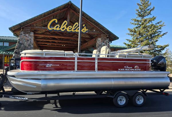 Sun Tracker Party Barge 22 DLX 2025 Sun Tracker Party Barge 22 DLX pontoon boat outside Cabela's store.