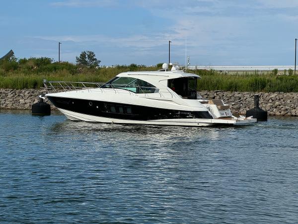 Cruisers cantius 2014 Cruisers Cantius yacht on calm water near a rocky shoreline.