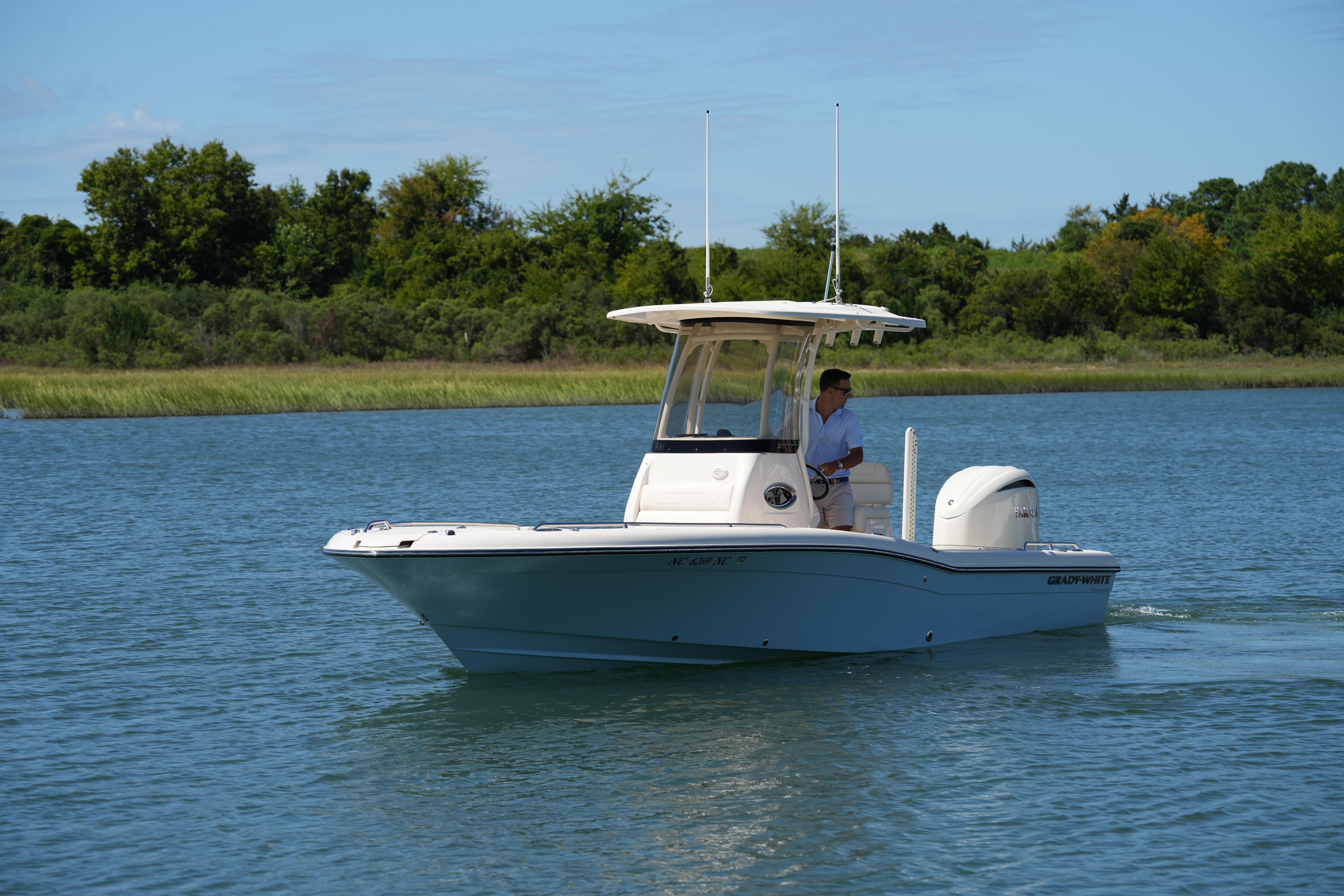 Grady-White 251 Coastal Explorer 2024 Grady-White 251 Coastal Explorer boat cruising on a serene lake.