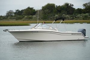 Grady-White Freedom 235 2022 Grady-White Freedom 235 boat on calm water, surrounded by lush greenery.