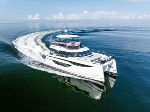 Prestige M48 2025 Prestige M48 yacht cruising on calm ocean waters under a clear blue sky.