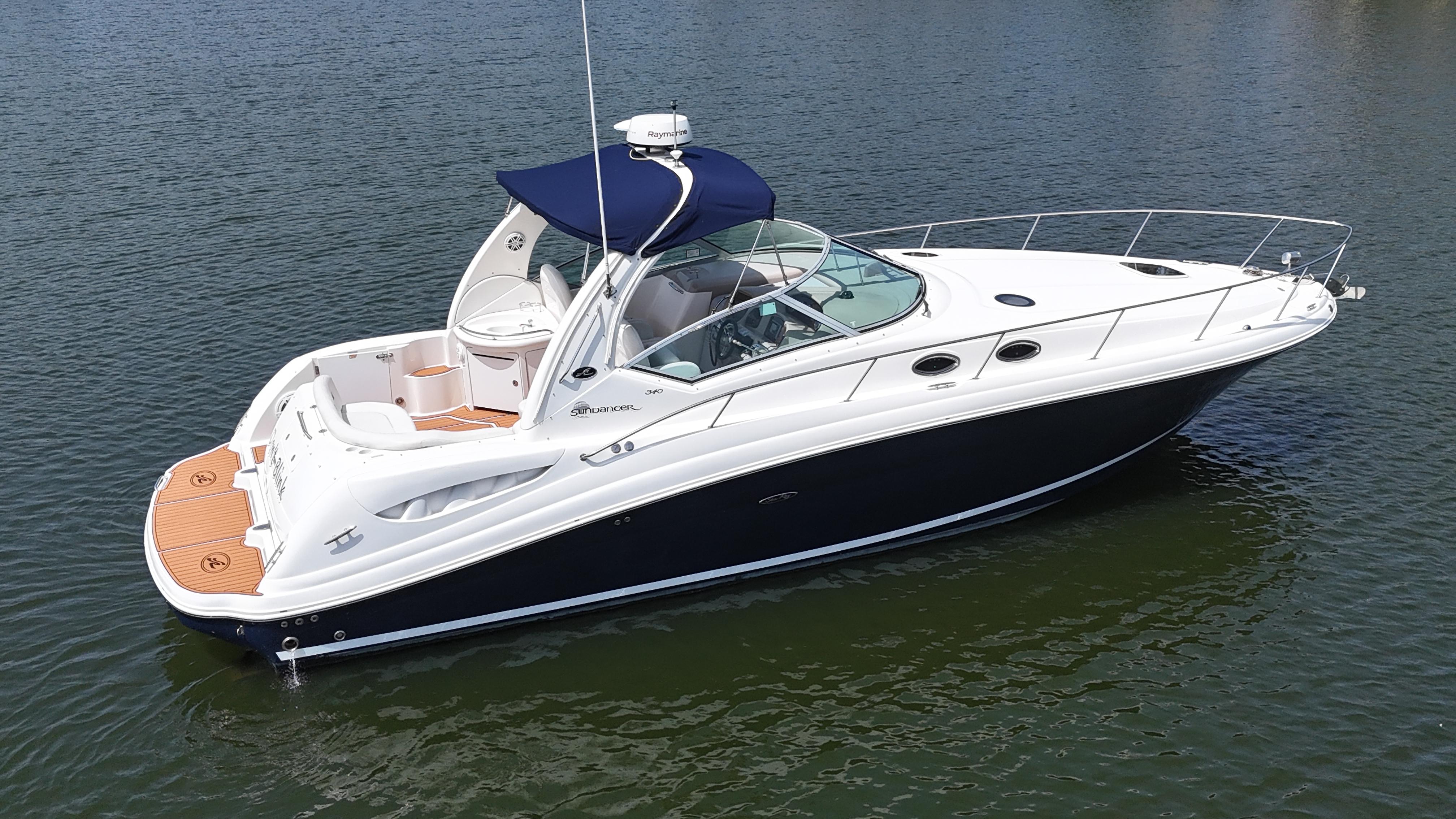 Sea Ray 340 Sundancer 2005 Sea Ray 340 Sundancer yacht on calm water, featuring sleek design and blue canopy.
