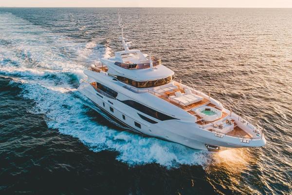 Benetti 95 Delfino Co Ownership Luxurious 2020 Benetti Delfino yacht cruising on open sea at sunset.