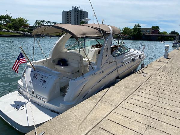 Sea Ray 280 Sundancer 2004 Sea Ray 280 Sundancer docked by a riverside with an American flag.