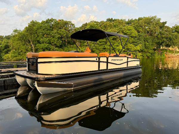 Premier 250 Sunsation Rear Social 2025 Premier 250 Sunsation Rear Social pontoon boat on calm lake with lush green trees.